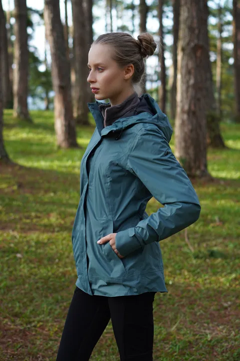 Karolina Juza — outdoor jacket in a pine forest