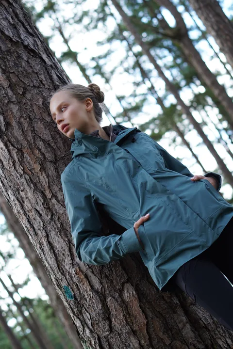 Karolina Juza — outdoor jacket in a pine forest